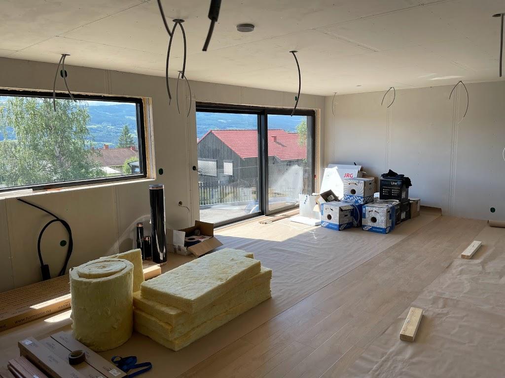 Stue under arbeid, med store vinduer og isolasjon på gulvet